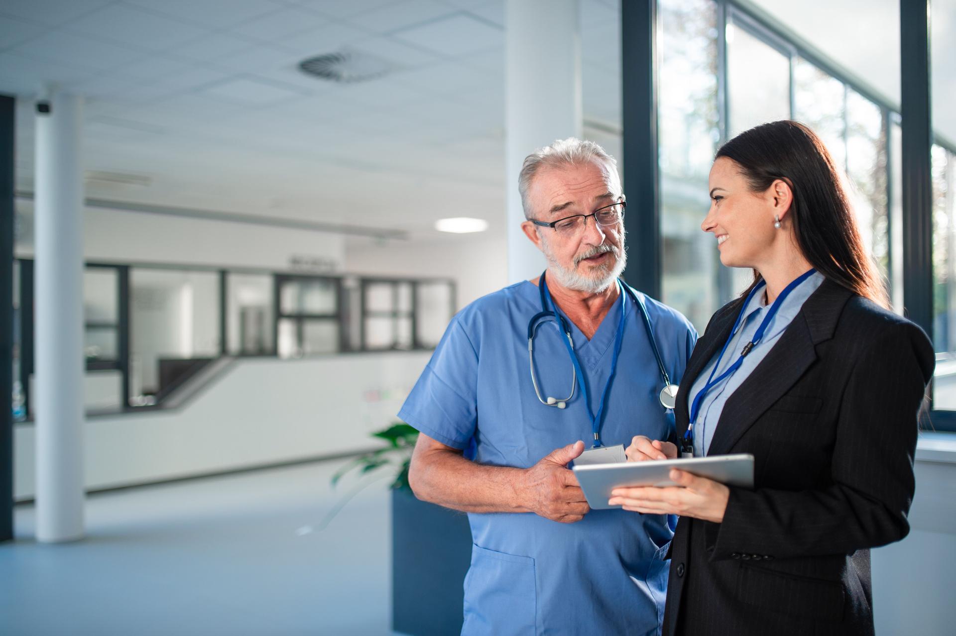 Young business woman shaking hand with elderly doctor.