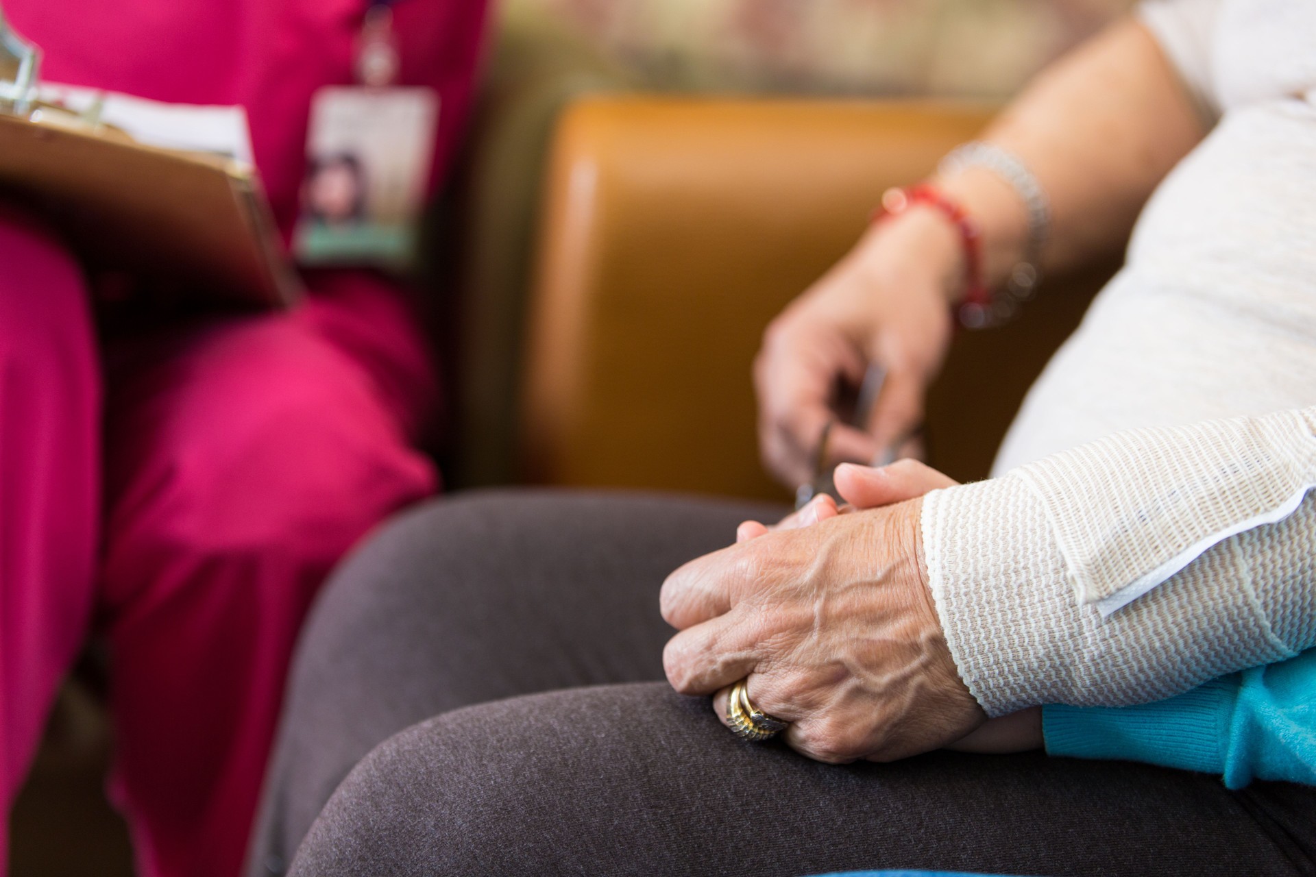 Granddaughter holds grandmother's hand at doctor appointment