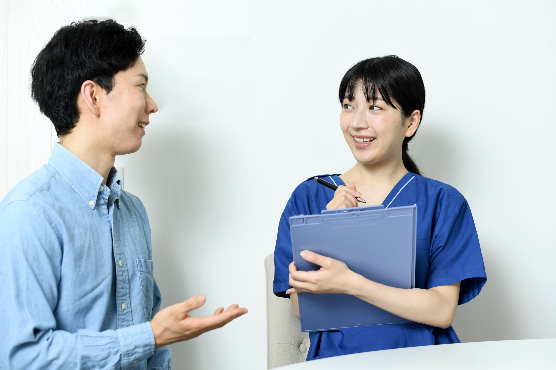 Young Asian male patient consulting a young Asian female healthcare worker