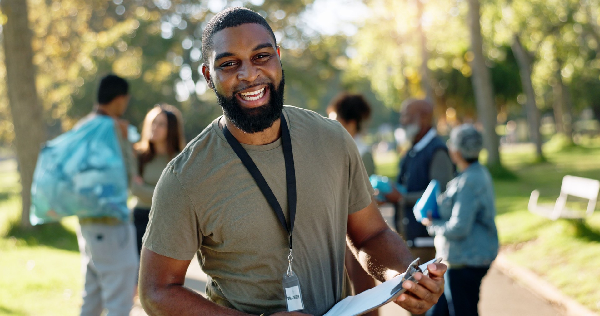 Man, volunteer and happy portrait with clipboard in nature, supervisor and environment sustainability project with group. Recycle, waste management and cleaning outside trash, help and ngo support